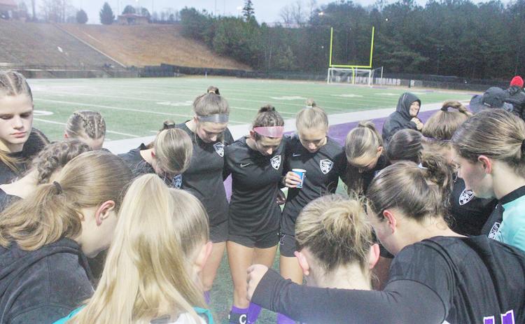 The Lumpkin County High School girls’ soccer team takes a moment before their big game.