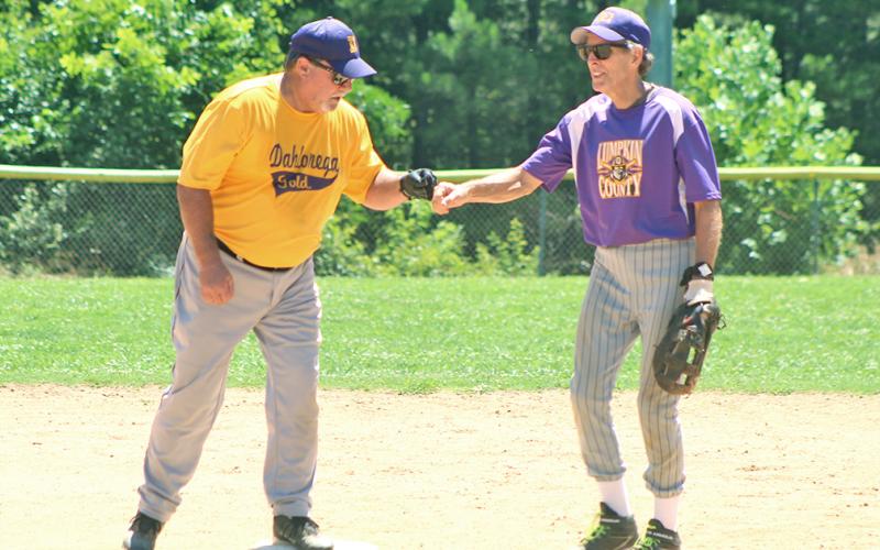 Miners second baseman Larry “Motoring” Morton congratulates the Dahlonega Gold’s Mike “Walloping” Williams after Williams belted a double in game two of a non-league doubleheader last week.